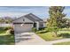 Charming single-story home featuring well-manicured lawn and attached two-car garage at 19724 Post Island Loop, Land O Lakes, FL 34638