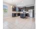 Modern kitchen with dark cabinetry, stainless steel appliances, island, and tiled floor at 19724 Post Island Loop, Land O Lakes, FL 34638