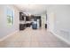 Modern kitchen features dark cabinets, stainless steel appliances, an island, and tile flooring at 19724 Post Island Loop, Land O Lakes, FL 34638