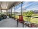 The screened lanai features a seating area and grill with scenic backyard views at 19724 Post Island Loop, Land O Lakes, FL 34638