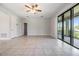 Open-concept living room boasts tile floors, sliding glass doors, and neutral-colored walls at 19724 Post Island Loop, Land O Lakes, FL 34638