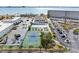 Aerial view showcasing community tennis courts, pool, and waterfront scenery at 3010 59Th S St # 304, Gulfport, FL 33707