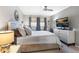 This bedroom features a ceiling fan, large television, and neutral decor for a relaxing atmosphere at 3010 59Th S St # 304, Gulfport, FL 33707