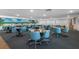 Clubhouse with multiple tables, blue chairs, and a beach mural on the left wall at 3010 59Th S St # 304, Gulfport, FL 33707