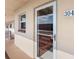 Exterior entrance of unit 304 with a white frame door and a window to the left on a beige exterior at 3010 59Th S St # 304, Gulfport, FL 33707