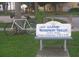 A sign for the free Gulfport waterfront trolley service is displayed next to a bicycle and shaded bench at 3010 59Th S St # 304, Gulfport, FL 33707