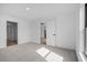 A bedroom featuring neutral carpeting, white walls, and view into other areas of the home at 3560 Bellefonte Ave, North Port, FL 34286