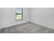 An empty bedroom with carpeting, bright window, and a neutral color scheme at 3560 Bellefonte Ave, North Port, FL 34286