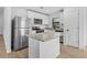 Modern kitchen with stainless steel appliances, white cabinets, a granite island, and light wood-look floors at 3560 Bellefonte Ave, North Port, FL 34286