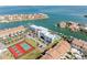 Aerial view featuring waterfront condos, tennis courts, and boat docks with stunning views of the serene water at 363 Pinellas Bayway S # 41, Tierra Verde, FL 33715