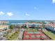 This aerial view showcases tennis courts, well-maintained landscaping, and stunning water views at 363 Pinellas Bayway S # 41, Tierra Verde, FL 33715