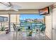 Balcony with chairs overlooks water and neighboring homes and boasts ceiling fan and tv at 363 Pinellas Bayway S # 41, Tierra Verde, FL 33715
