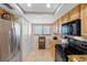 Bright kitchen features tan cabinetry, granite countertops, stainless steel appliances, and a wine rack at 363 Pinellas Bayway S # 41, Tierra Verde, FL 33715