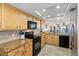 Bright kitchen features tan cabinetry, granite countertops, stainless steel appliances, and open floor plan at 363 Pinellas Bayway S # 41, Tierra Verde, FL 33715