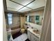 Retro bathroom features a tub with shower, vanity with marble countertop, and decorative accents at 3722 Haven Dr, New Port Richey, FL 34652