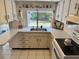 Traditional kitchen featuring white cabinets, neutral countertops, and a window overlooking the backyard at 3722 Haven Dr, New Port Richey, FL 34652