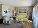 Bright living room with a vibrant yellow sofa, accent chairs, and floral decor at 3722 Haven Dr, New Port Richey, FL 34652