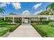 Exterior of clubhouse with symmetrical design, covered porch, and manicured landscaping at 4154 57Th N St # 173, Kenneth City, FL 33709