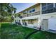 Condo exterior featuring awning, door, wrought iron, and air conditioning units on the side of the building at 4154 57Th N St # 173, Kenneth City, FL 33709