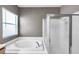 A well-lit bathroom featuring a soaking tub and a separate glass-enclosed shower at 4506 Mapletree Loop, Wesley Chapel, FL 33544