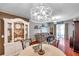 Open-concept dining area featuring decorative chandelier, hardwood floors, and a seamless flow to living space at 4506 Mapletree Loop, Wesley Chapel, FL 33544