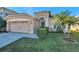 Charming home featuring a well-manicured lawn, palm tree, and a two-car garage at 4506 Mapletree Loop, Wesley Chapel, FL 33544