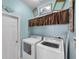 This laundry room has tile floors, a large window, and a full sized washer and dryer at 4506 Mapletree Loop, Wesley Chapel, FL 33544