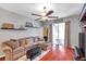 Comfortable living area featuring a cozy sectional sofa, ceiling fan, sliding glass doors, and stylish decor at 4506 Mapletree Loop, Wesley Chapel, FL 33544