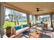 This sunroom features neutral decor, panoramic views of the yard, and lots of space at 4506 Mapletree Loop, Wesley Chapel, FL 33544