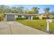 A charming one-story home with a gray garage door, green lawn, and a concrete driveway at 4519 S Hesperides St, Tampa, FL 33611