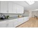 Modern kitchen featuring ample counter space, white cabinets, and stainless steel appliances with wood flooring, and great light at 4519 S Hesperides St, Tampa, FL 33611