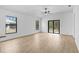 Bright living room with white walls, wood look tile flooring, and sliding glass door at 5237 Aberback St, North Port, FL 34291
