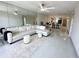 Bright living room with tile floors, large sectional sofa, and mirrored wall reflecting ample space at 5400 Park N St # 209, St Petersburg, FL 33709