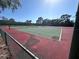 Outdoor tennis courts surrounded by lush trees and a clear blue sky at 5400 Park N St # 209, St Petersburg, FL 33709