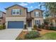 Charming two-story home featuring a blue garage door, complemented by lush landscaping and vibrant blue shutters at 6216 Kevesta Ave, Palmetto, FL 34221