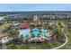 Aerial view of a community pool with palm trees and a clubhouse in a residential neighborhood at 6216 Kevesta Ave, Palmetto, FL 34221