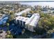 An aerial shot showcases the condominium complex with a pool, ample parking, surrounded by lush greenery and a lake at 90 S Highland Ave # 423, Tarpon Springs, FL 34689