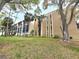 Multi-story condominium with mature trees and greenery providing shade to the building's exterior at 90 S Highland Ave # 423, Tarpon Springs, FL 34689