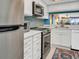 Bright kitchen with white cabinets, updated appliances, and a colorful rug at 90 S Highland Ave # 423, Tarpon Springs, FL 34689
