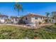 Exterior view of a one-story home with a backyard patio and palm trees at 911 Boca Ciega Isle Dr, St Pete Beach, FL 33706