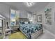 Cozy bedroom featuring a bed with blue patterned bedding, bright windows, and stylish decor at 204 Latitude Pl, Apollo Beach, FL 33572