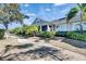 Charming single-story home featuring lush tropical landscaping, a covered porch, and a welcoming walkway at 204 Latitude Pl, Apollo Beach, FL 33572