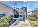 Enclosed screened-in patio with a brick-paved walkway and lush landscaping surrounding the area at 204 Latitude Pl, Apollo Beach, FL 33572