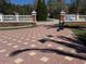 Gated entryway featuring a decorative paved driveway and ornate columns, enhancing the property's curb appeal at 27826 Robin Roost Ln, Wesley Chapel, FL 33544