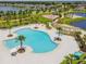 Aerial view of community pool featuring winding design, ample seating, playground, and lake views at 11127 Hudson Hills Ln, Riverview, FL 33579
