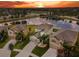 A landscape aerial view of a neighborhood property at sunset featuring a lake view and backyard at 11127 Hudson Hills Ln, Riverview, FL 33579