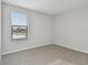 Minimalist bedroom featuring neutral carpet, white walls, and a window with a lake view at 11127 Hudson Hills Ln, Riverview, FL 33579