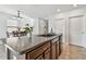 Granite kitchen island with dark cabinets, sink, and dining room in background at 11127 Hudson Hills Ln, Riverview, FL 33579