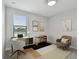 Stylish home office with desk, chair, shelving, and bright natural light from window overlooking a lake at 11127 Hudson Hills Ln, Riverview, FL 33579