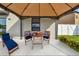 Outdoor patio area showcasing a seating area with a table and lounge chair under a gazebo at 11127 Hudson Hills Ln, Riverview, FL 33579
